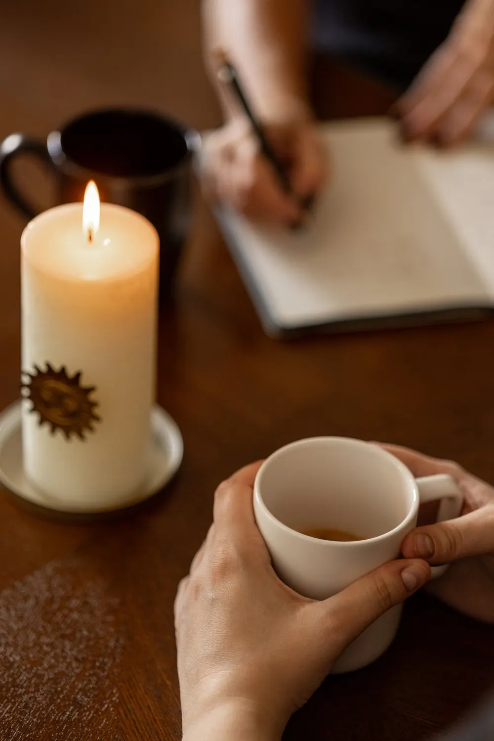 Bougie ornée d'un soleil et tasse de thé sur une table en bois